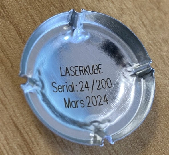 Vue du dessous d’une capsule de bouchon de champagne portant des informations variables de traçabilité