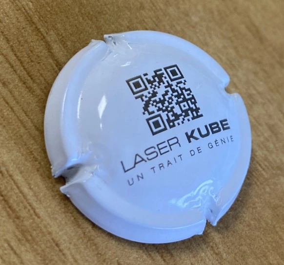 Vue du dessus peint d’une capsule de bouchon de champagne après travail laser, avec un code 2D et un motif