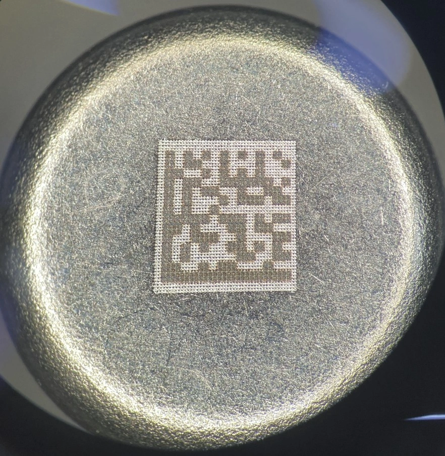 Vista ravvicinata di un DataMatrix 2 × 2 mm marcato con laser MOPA 20 W sul fondo di una capsula in inox