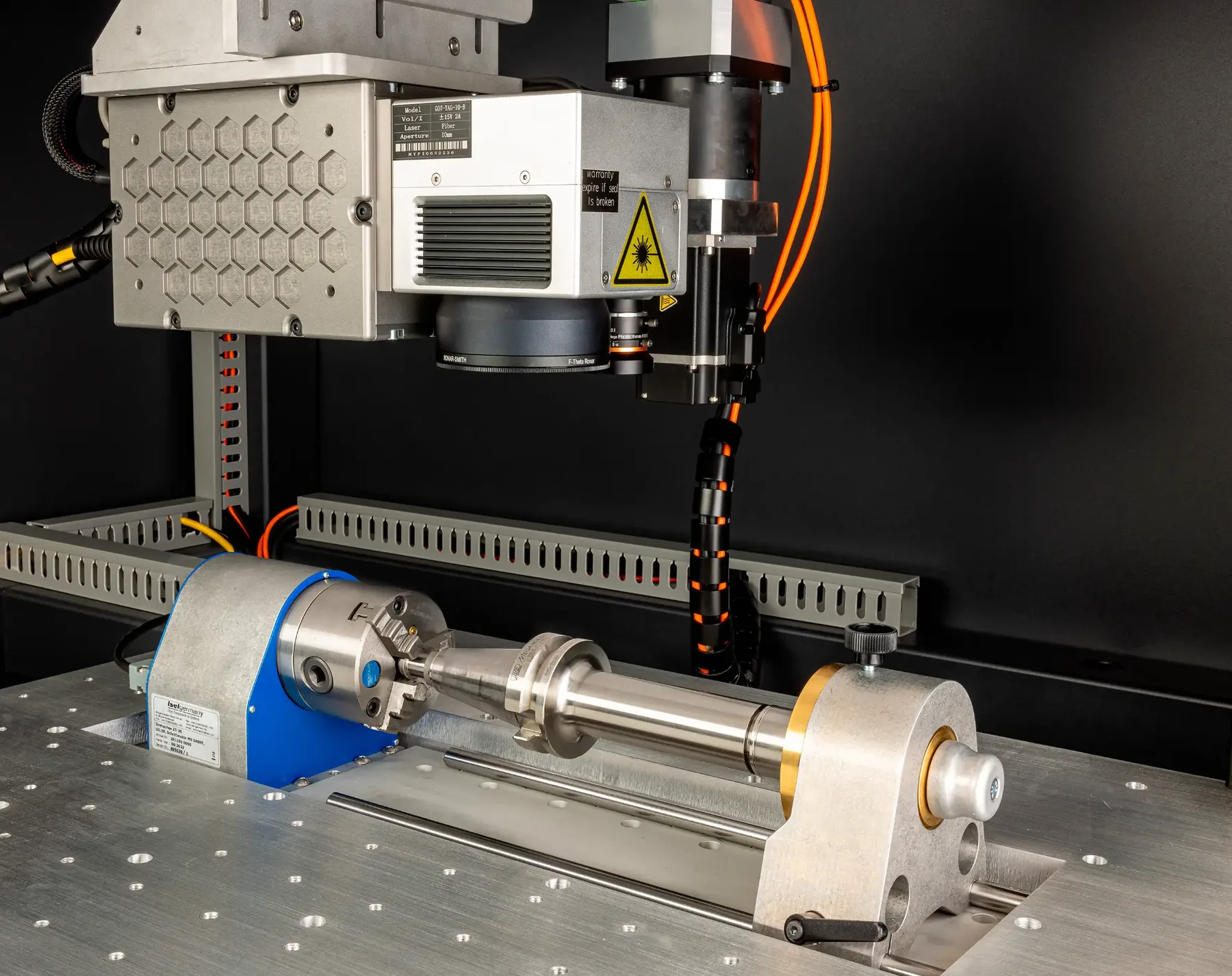 Mandrin rotatif, contrepointe et tête laser au-dessus d’une pièce cylindrique